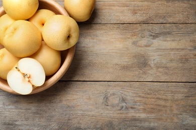 Photo of Cut and whole apple pears on wooden table, flat lay. Space for text