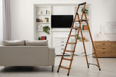 Photo of Wooden folding ladder in stylish living room