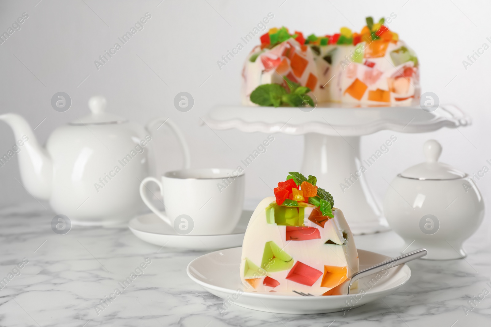 Photo of Delicious broken glass jelly dessert on white marble table, space for text