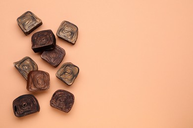 Photo of Different tasty chocolate candies on beige background, flat lay. Space for text