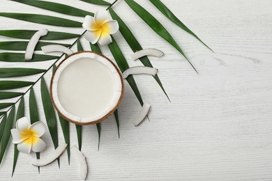 Photo of Flat lay composition with half of coconut on white wooden background. Space for text