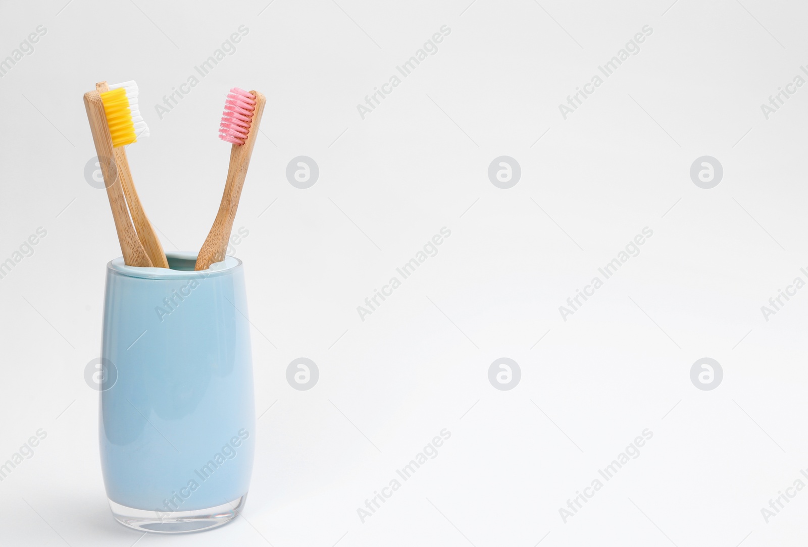 Photo of Bamboo toothbrushes in holder isolated on white