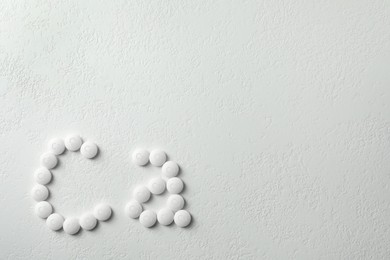 Photo of Flat lay composition with calcium supplement pills on white background, space for text