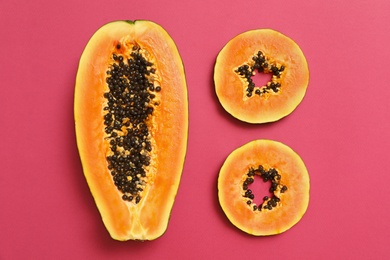 Flat lay composition with cut papaya on pink background