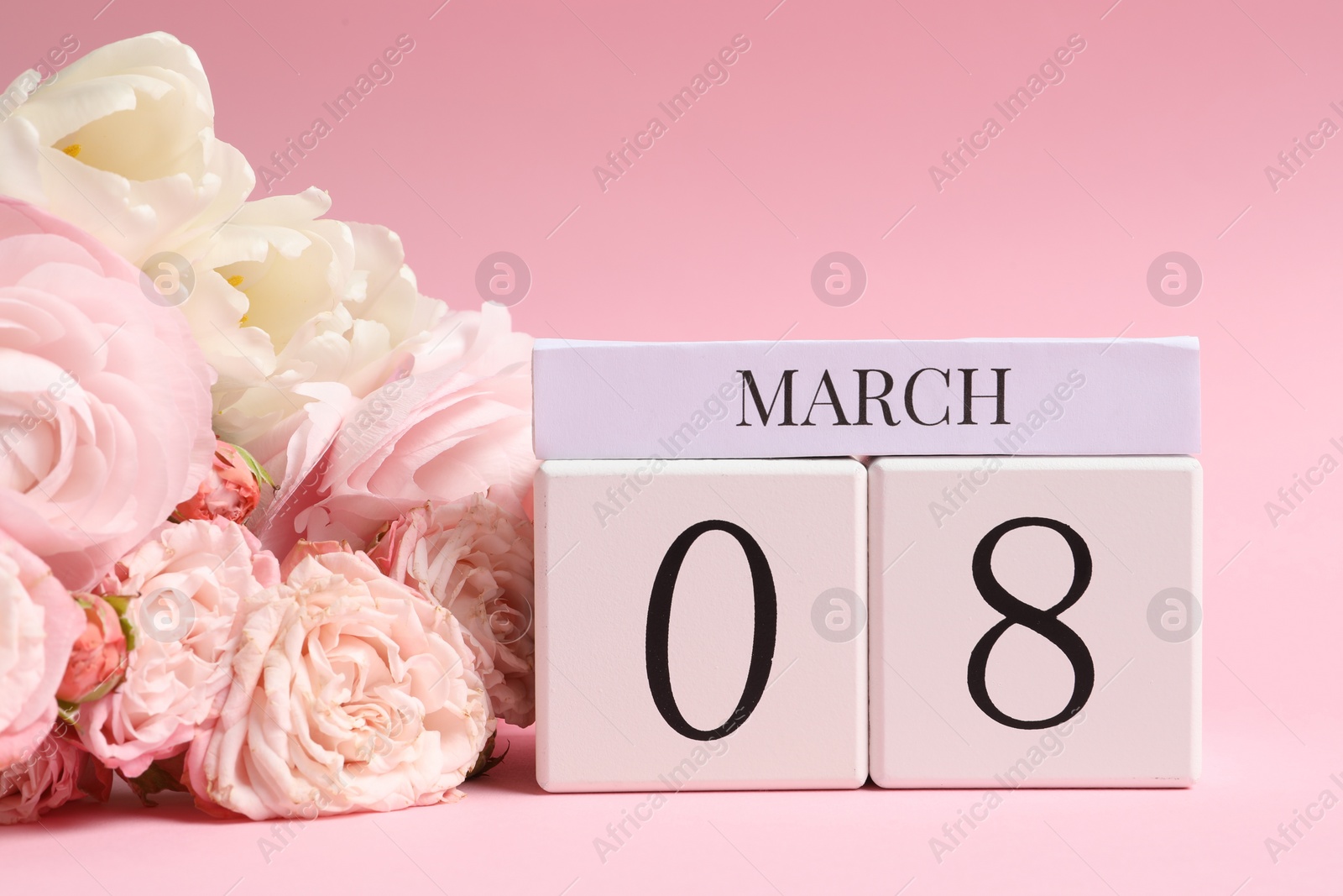 Photo of International Women's day - 8th of March. Wooden block calendar and beautiful flowers on pink background