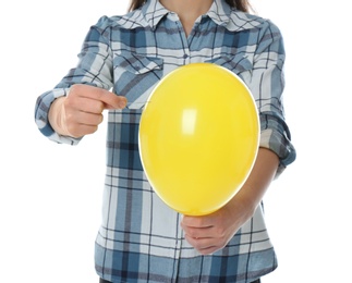 Woman piercing yellow balloon on white background, closeup