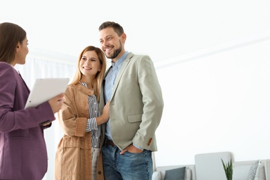 Female real estate agent working with couple in room