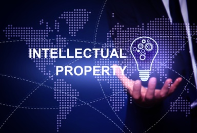 Intellectual property concept. Man with light bulb and world map illustrations, closeup