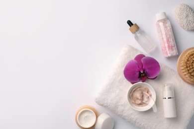 Photo of Flat lay composition with different spa products and beautiful flower on white table. Space for text