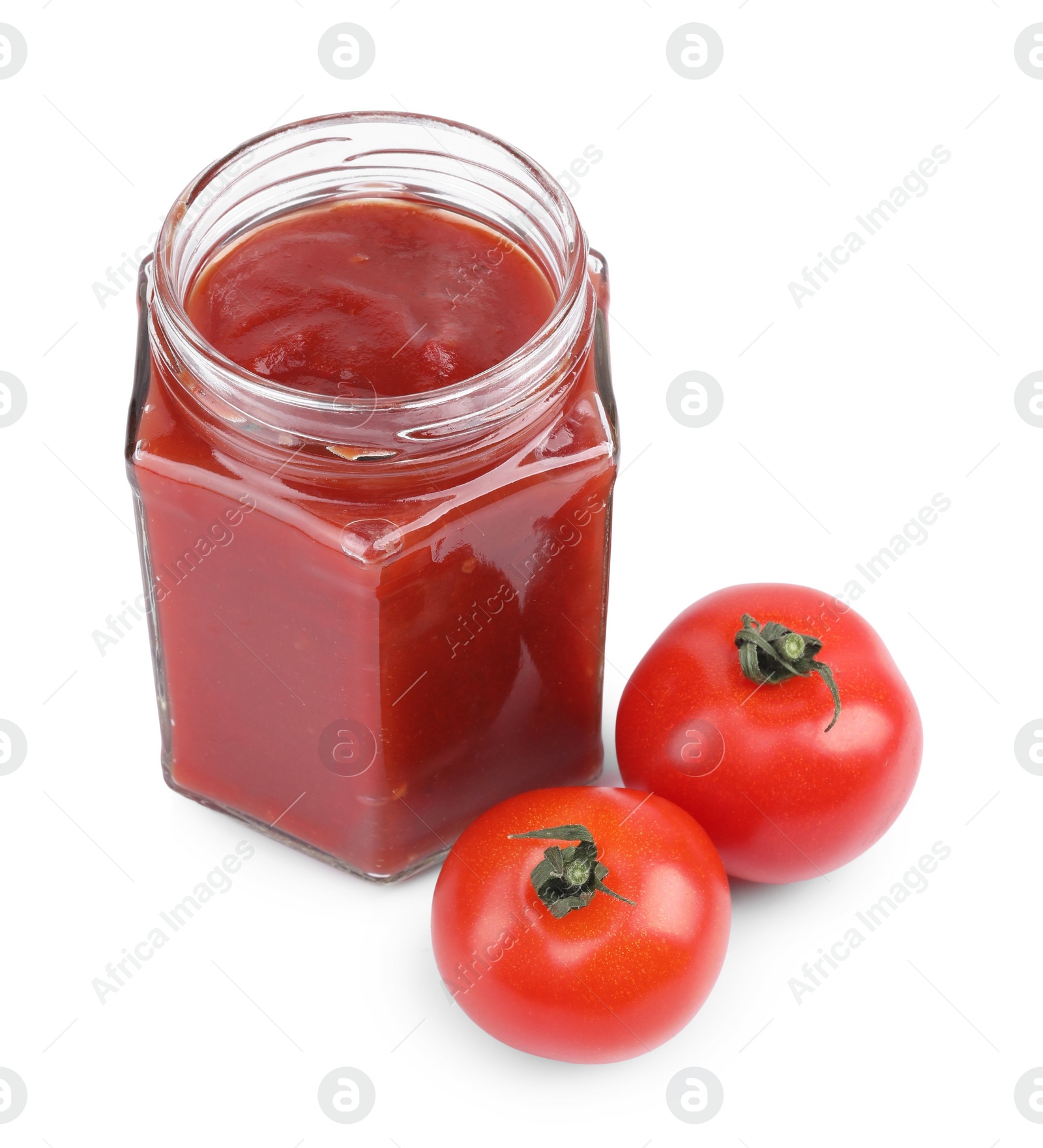 Photo of Organic ketchup in glass jar and fresh tomatoes isolated on white. Tomato sauce