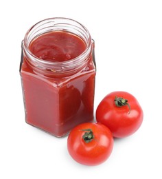 Organic ketchup in glass jar and fresh tomatoes isolated on white. Tomato sauce