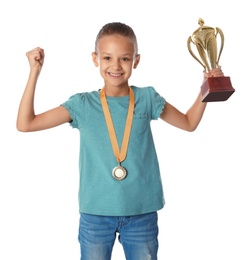 Happy girl with golden winning cup and medal on white background