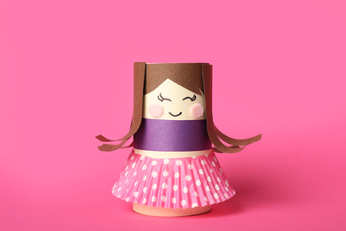 Photo of Toy doll made of toilet paper hub on pink background