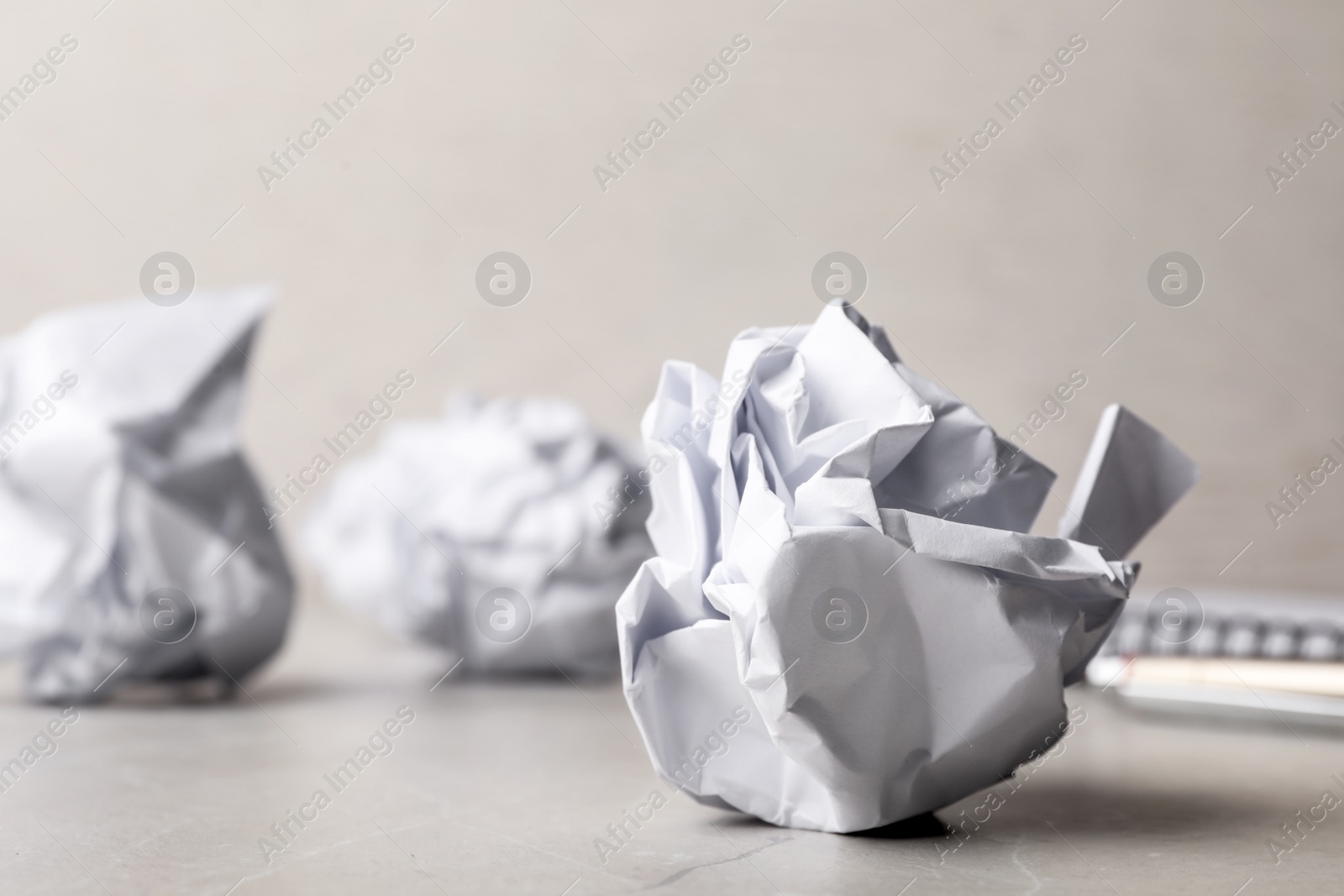 Photo of Ball of crumpled paper on grey table, space for text