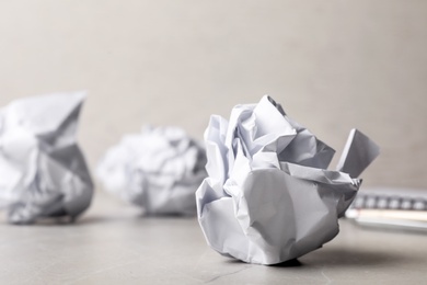 Ball of crumpled paper on grey table, space for text