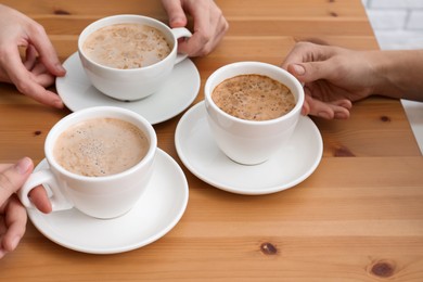 Women with cups of coffee at table in cafe, closeup