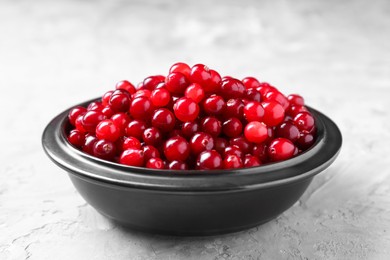 Photo of Fresh ripe cranberries in bowl on grey table, closeup