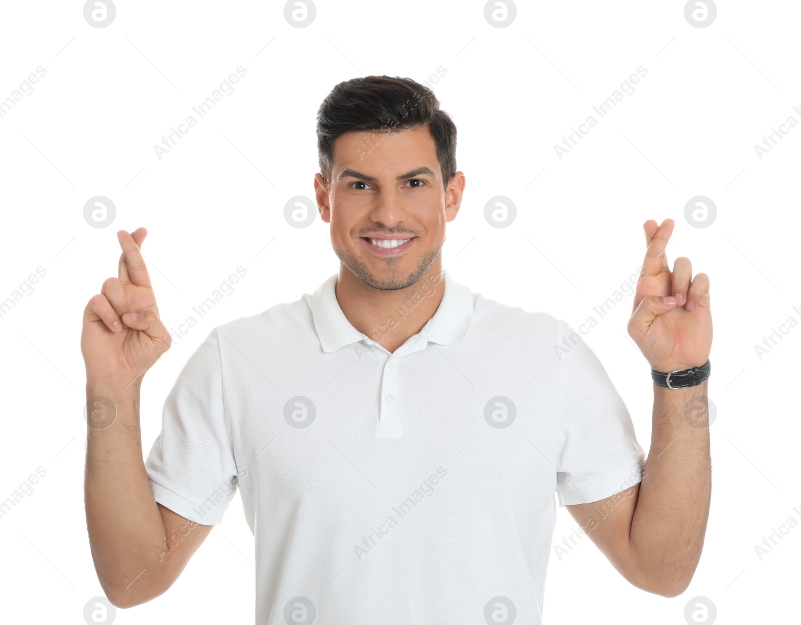 Photo of Man with crossed fingers on white background. Superstition concept