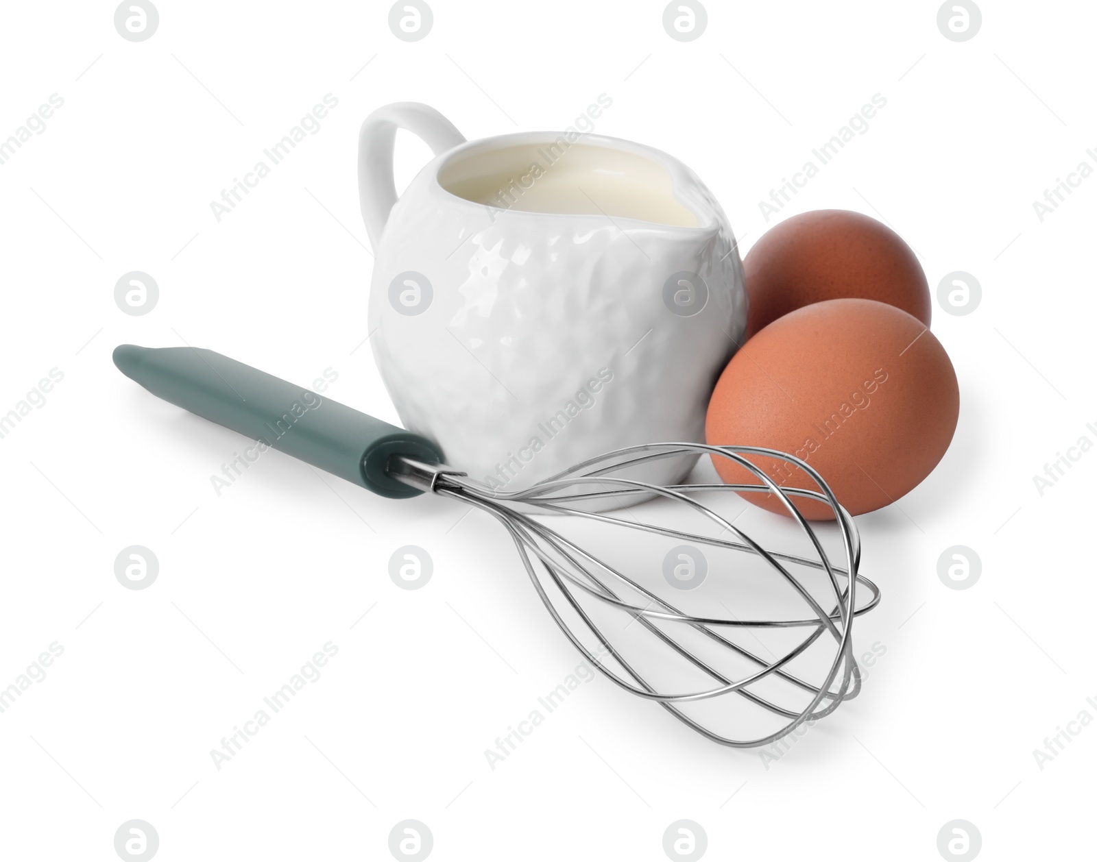 Photo of Whisk, raw eggs and jug of milk isolated on white