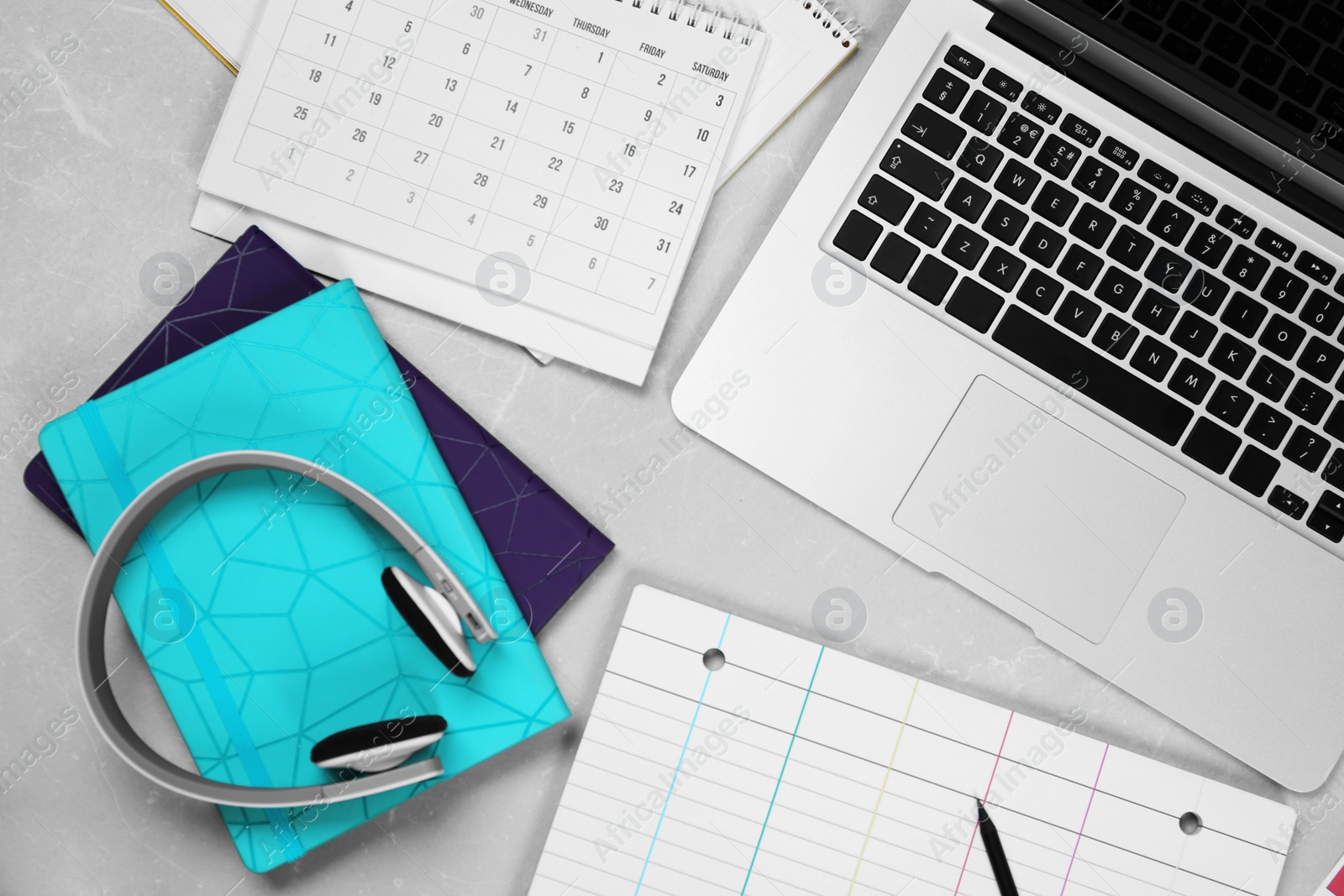 Photo of Flat lay composition with notebook and laptop on light grey marble table. Designer's workplace