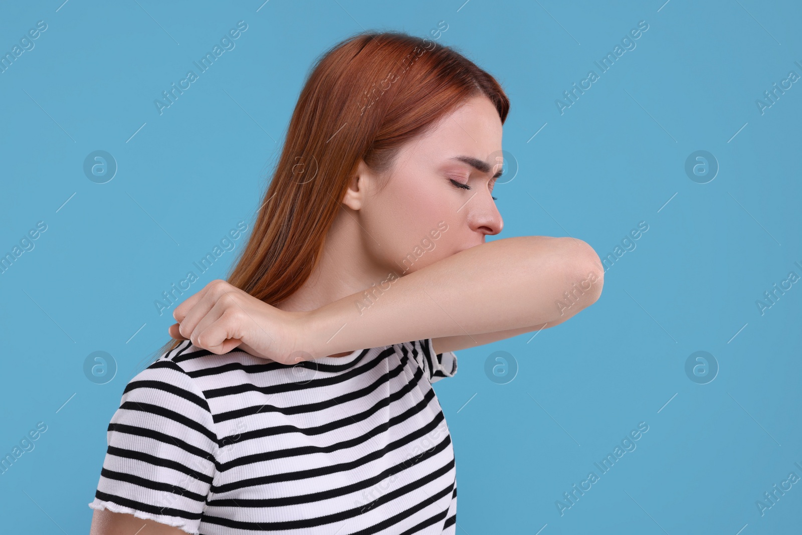 Photo of Woman coughing on light blue background. Cold symptoms