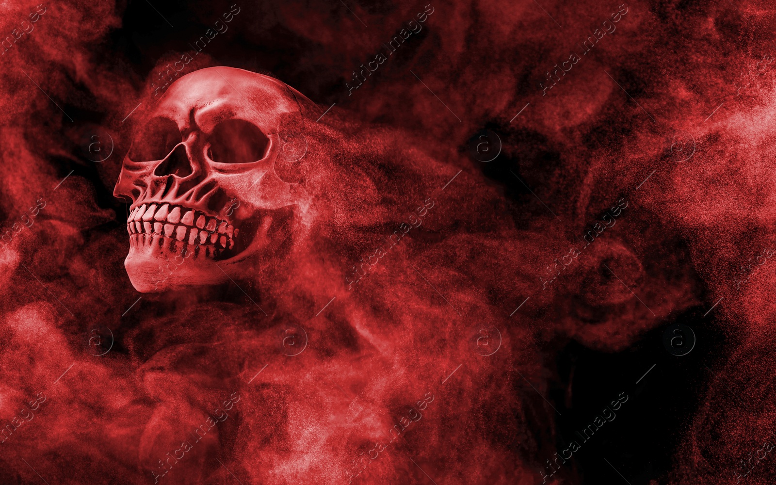 Image of Scary skull emerging from smoke in darkness