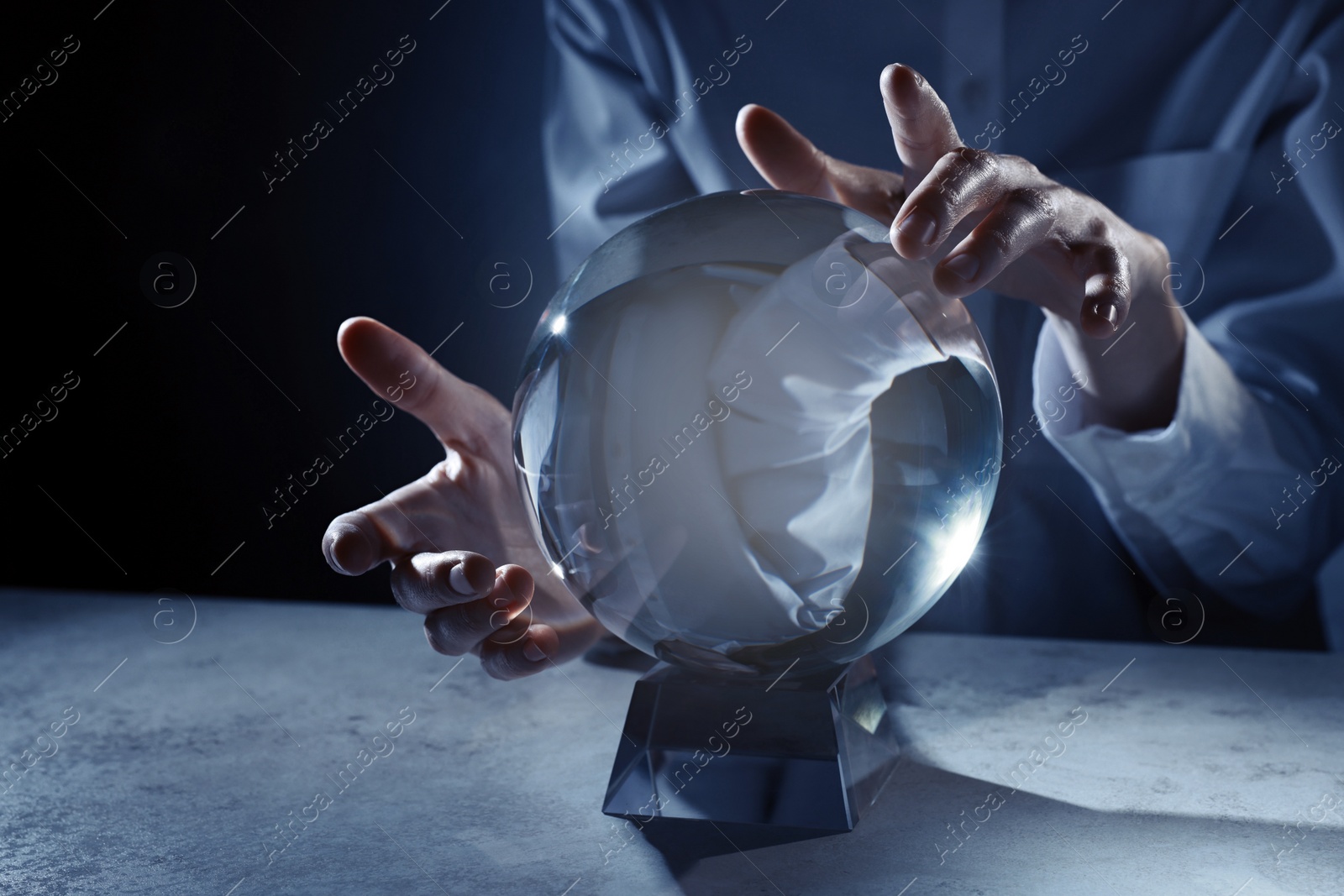 Photo of Businesswoman using crystal ball to predict future at table, closeup