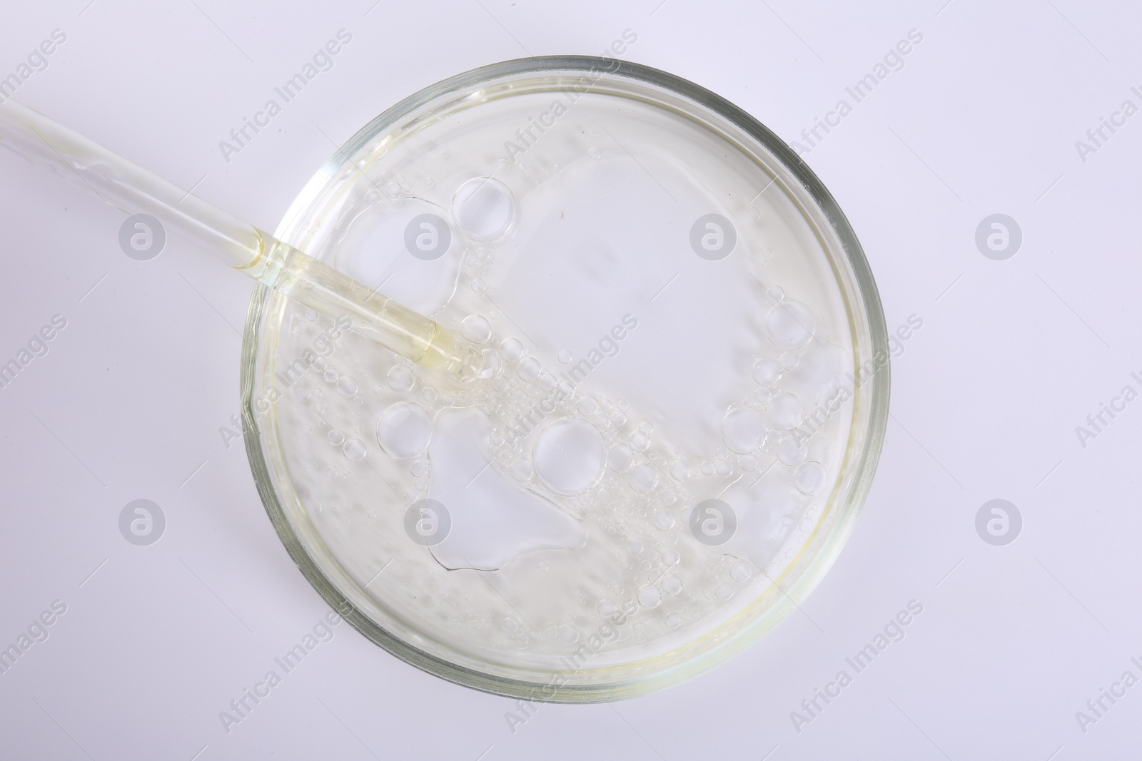 Photo of Petri dish with liquid sample and pipette isolated on white, top view