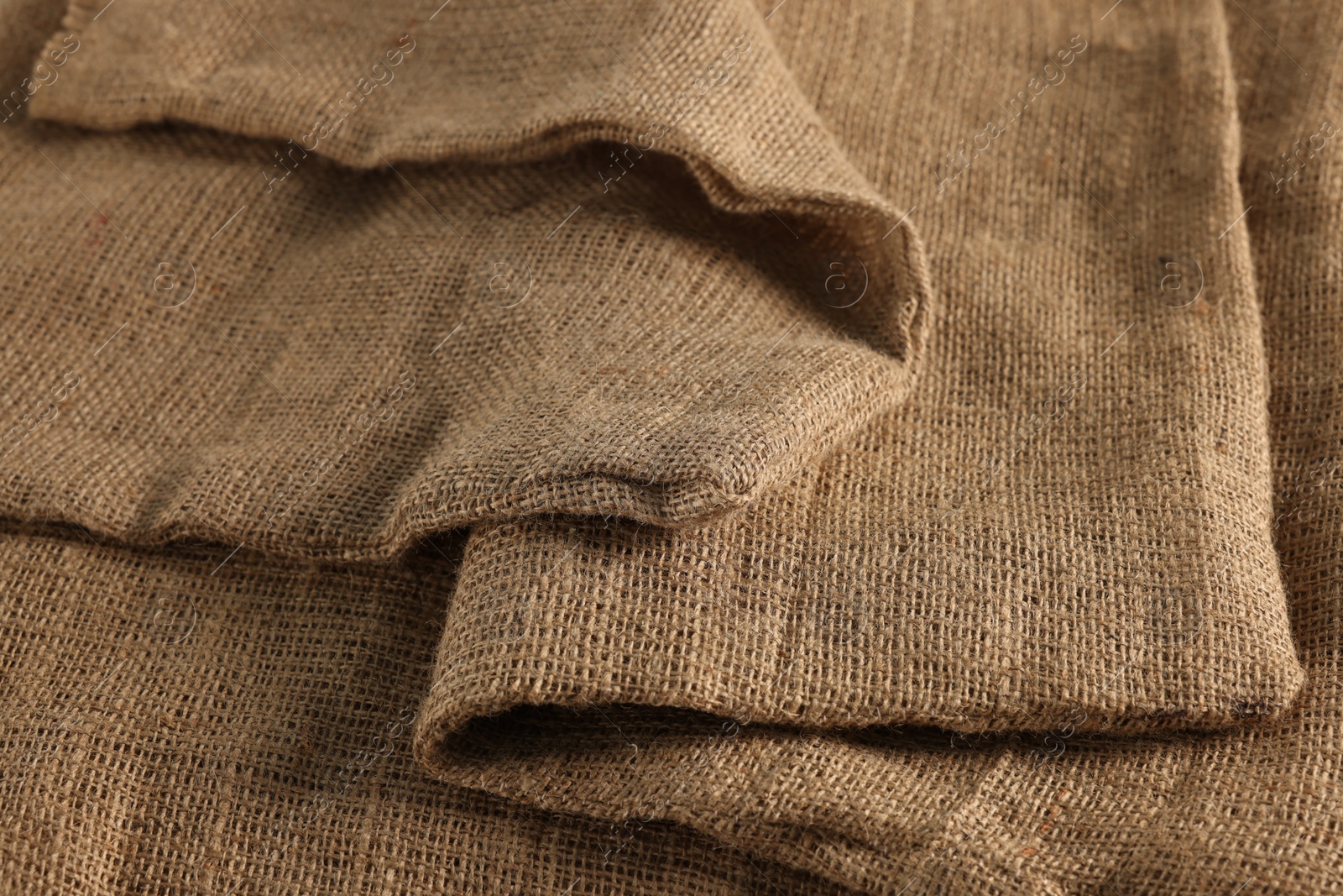 Photo of Texture of natural burlap fabric as background, closeup