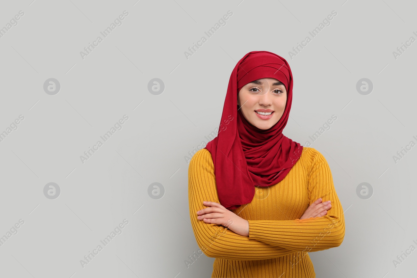 Photo of Portrait of Muslim woman in hijab on light gray background, space for text