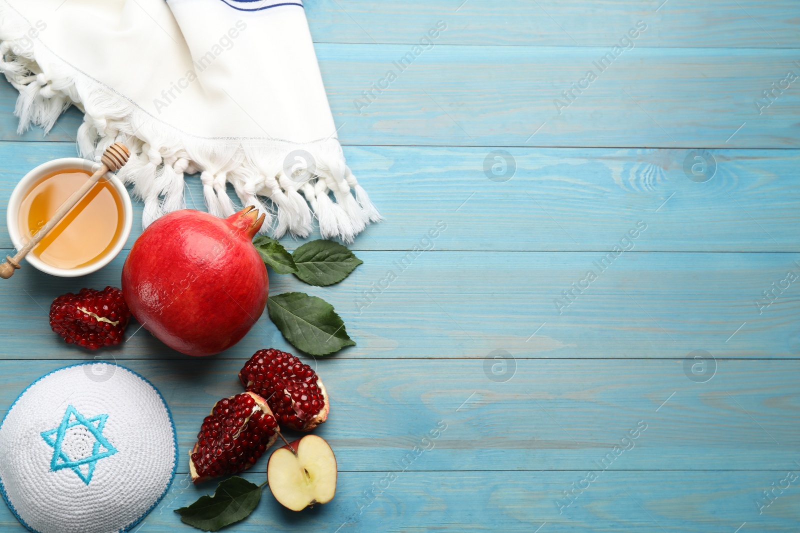 Photo of Flat lay composition with Rosh Hashanah holiday attributes on light blue wooden table. Space for text