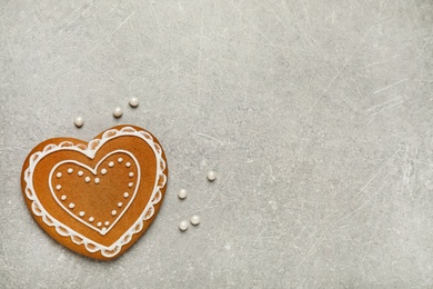 Tasty heart shaped gingerbread cookie on grey table, top view. Space for text