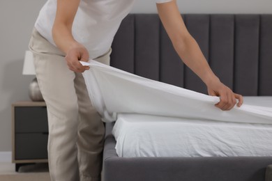 Woman changing bed linens at home, closeup