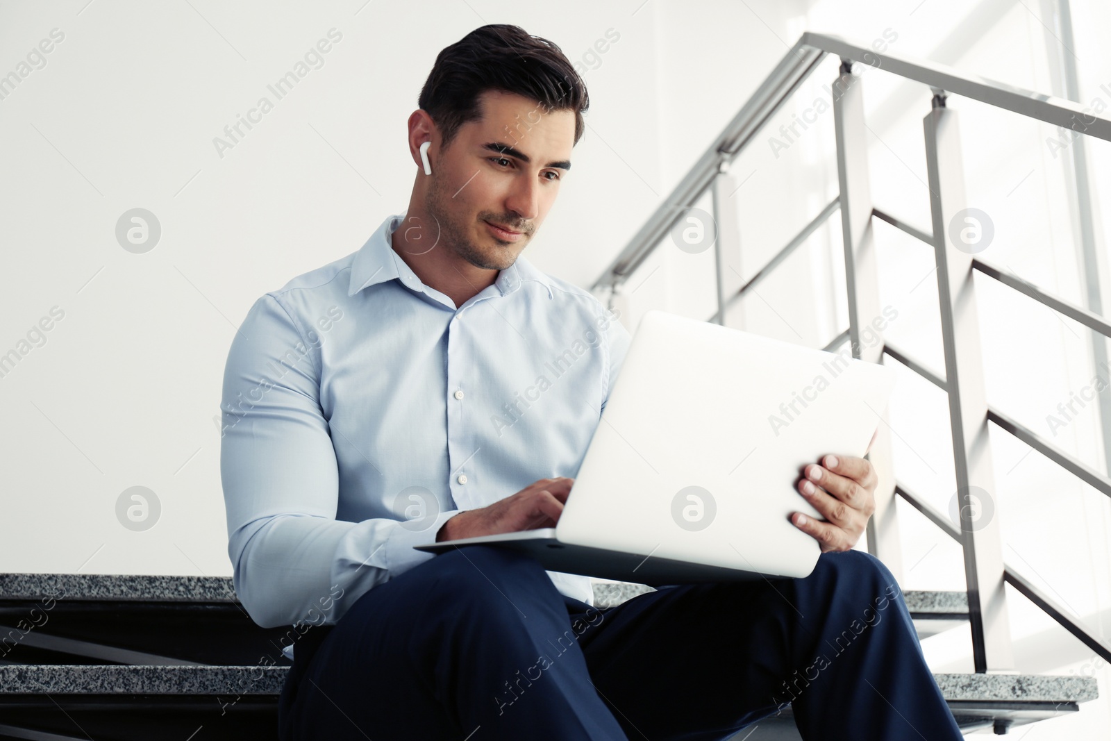 Photo of Portrait of young man with laptop indoors