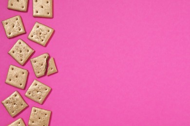 Golden cookies on pink background, flat lay. Space for text