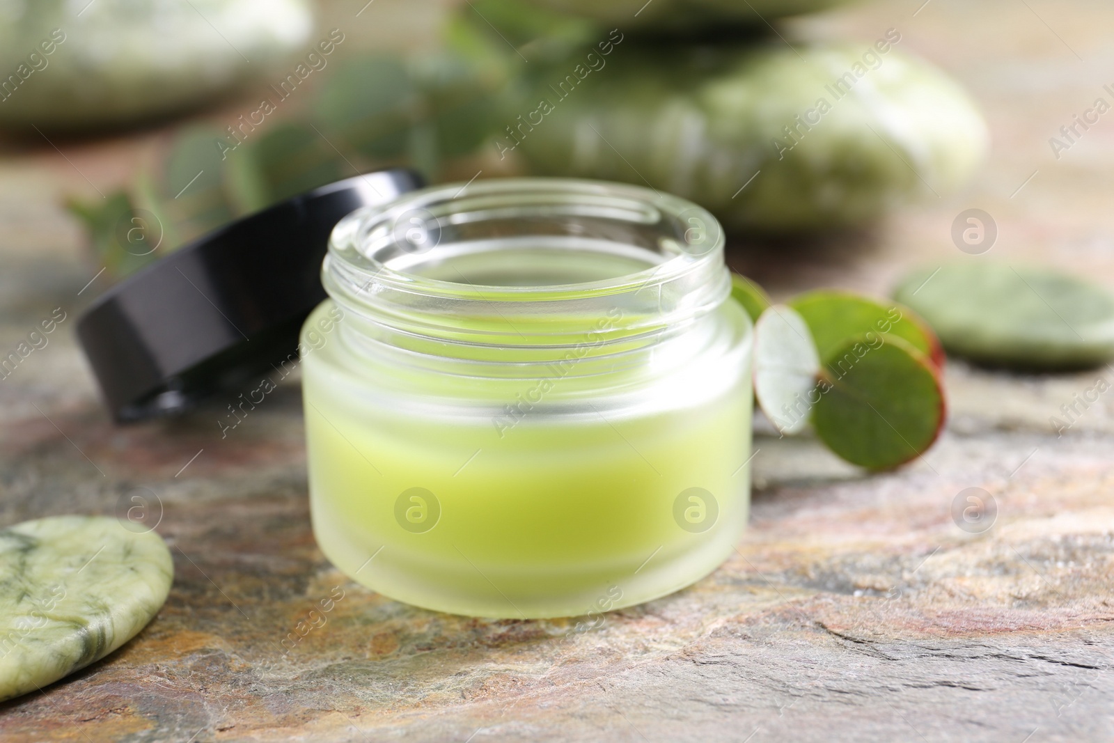 Photo of Jar of cream on textured table, closeup. Body care product