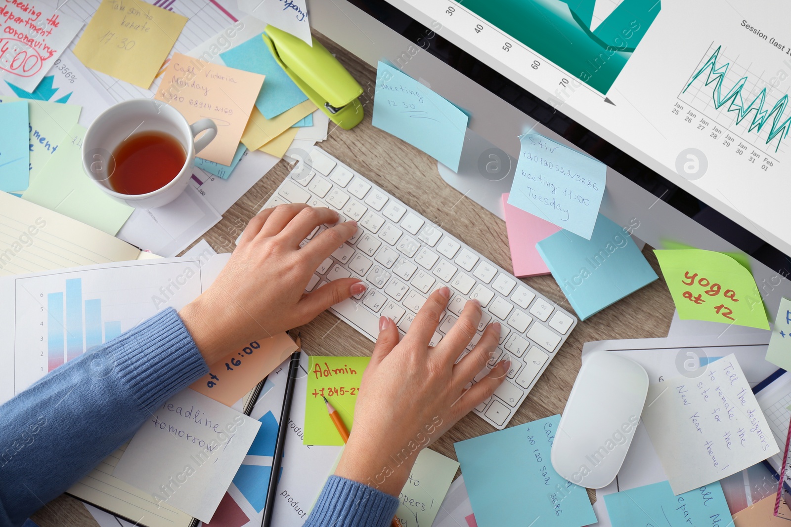 Photo of Overwhelmed woman working at messy office desk, above view