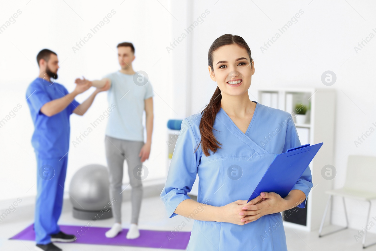 Photo of Young physiotherapist with clipboard in rehabilitation center