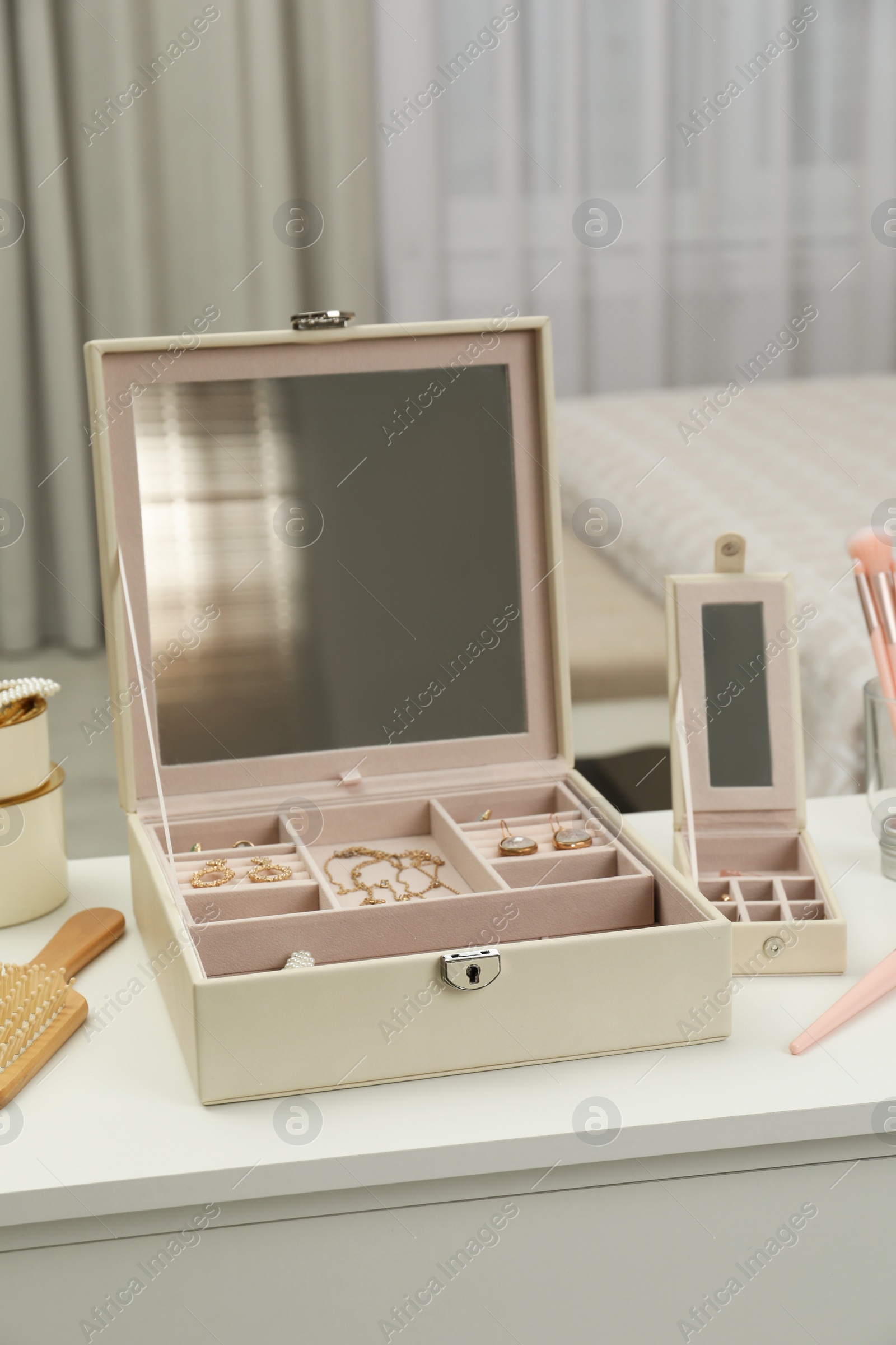 Photo of Elegant jewelry box with beautiful bijouterie on dressing table in bedroom