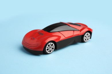 One red car on light blue background. Children`s toy