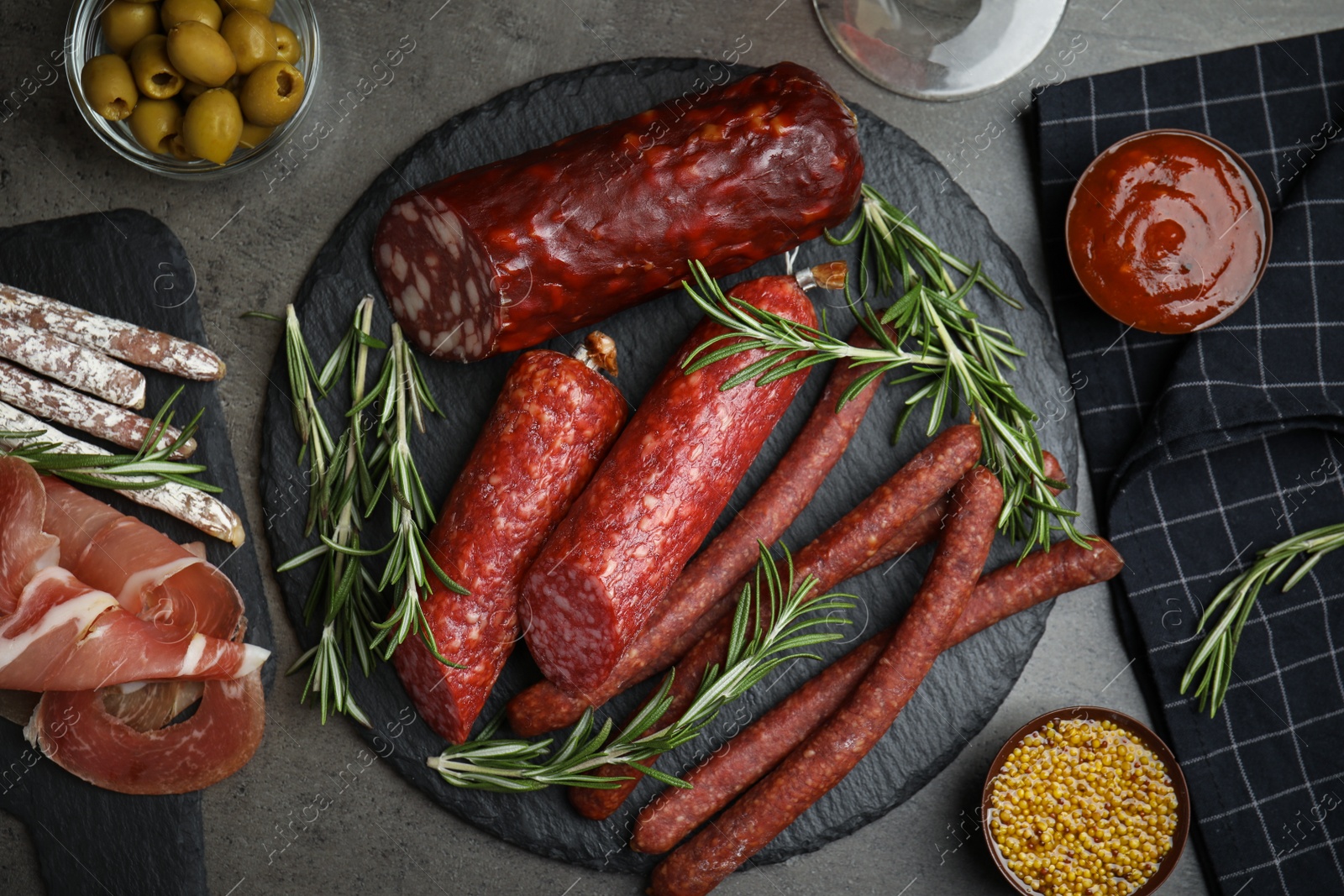 Photo of Different types of sausages served on grey table, flat lay