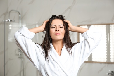 Image of Beautiful young woman with wet hair in bathroom