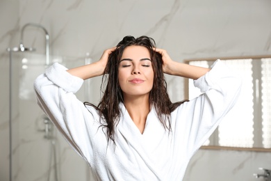 Beautiful young woman with wet hair in bathroom