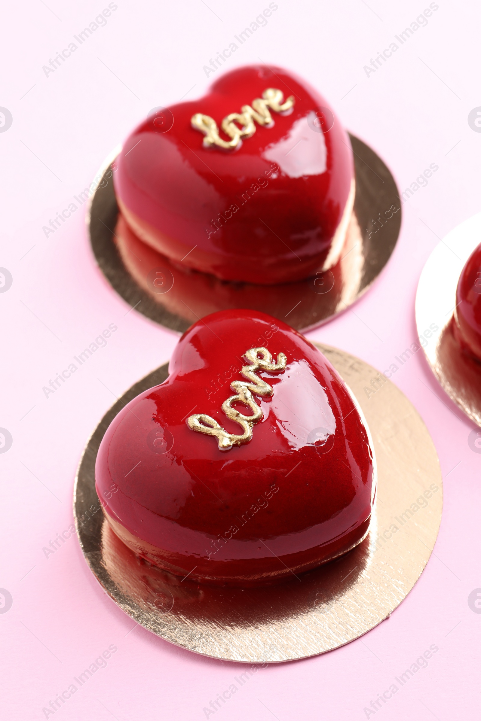 Photo of St. Valentine's Day. Delicious heart shaped cakes on light pink background, closeup