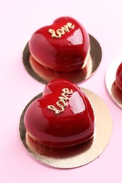 Photo of St. Valentine's Day. Delicious heart shaped cakes on light pink background, closeup
