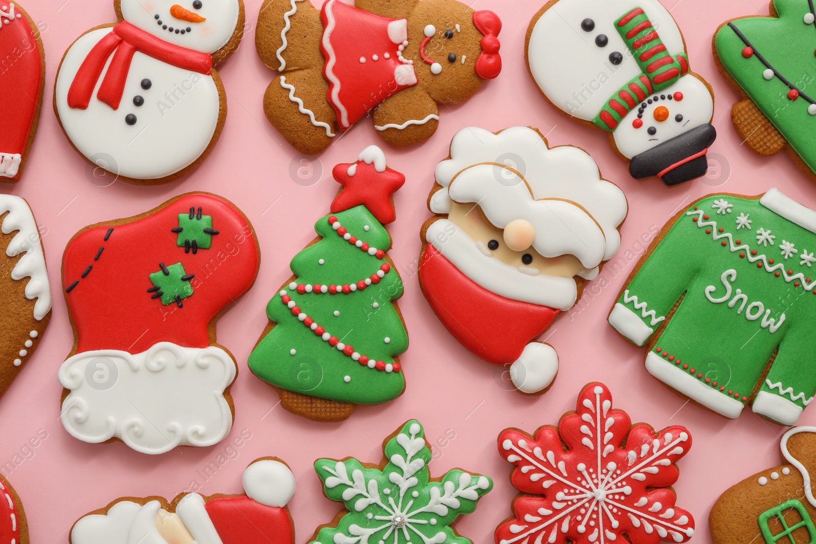 Photo of Different Christmas gingerbread cookies on pink background, flat lay