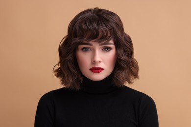 Photo of Portrait of beautiful young woman with wavy hairstyle on beige background