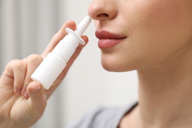 Medical drops. Woman using nasal spray at home, closeup