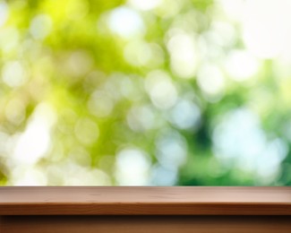 Image of Empty wooden surface against blurred green background. Space for design