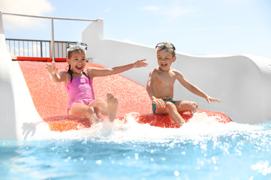Photo of Little children on slide at water park. Summer vacation